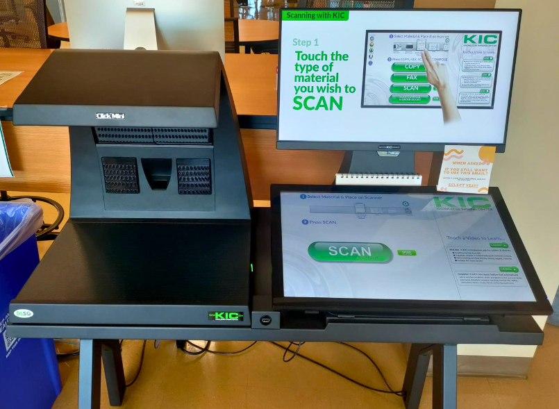 Photo of a KIC overhead scanner and accompanying control touchscreens.
